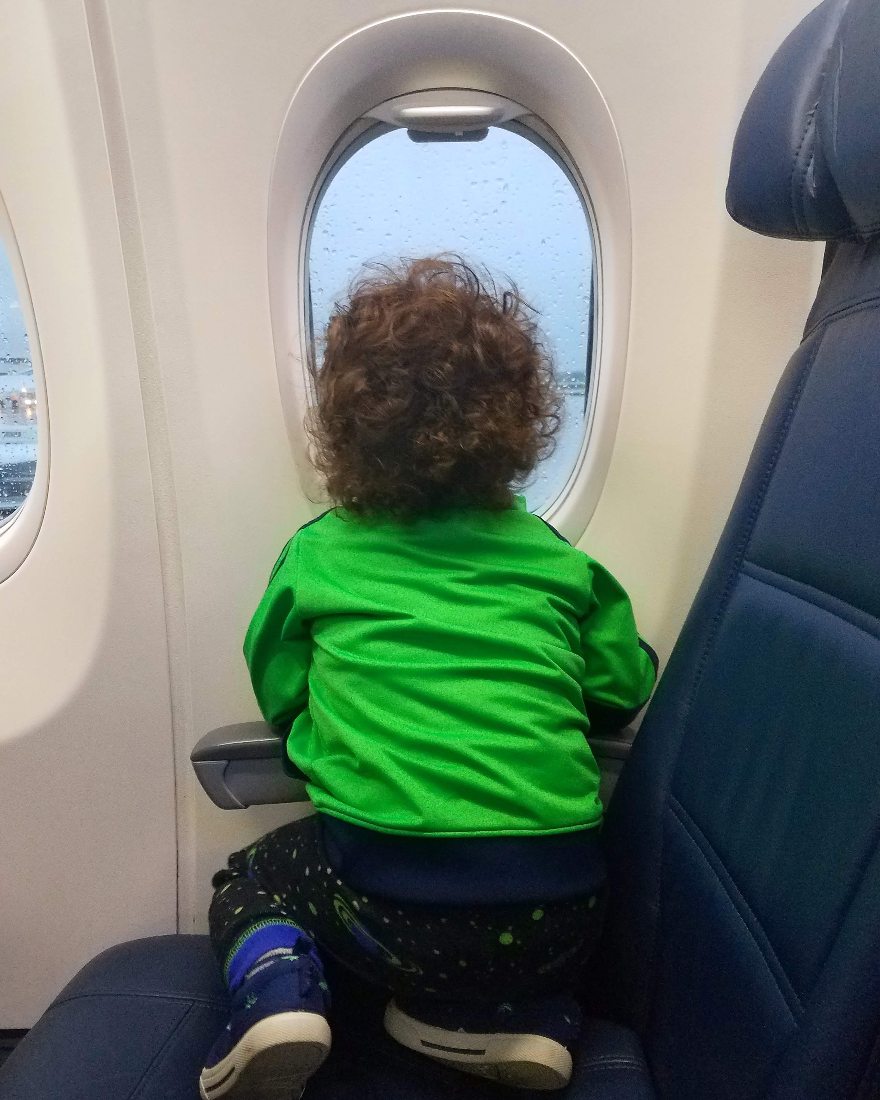 child looking out airplane window